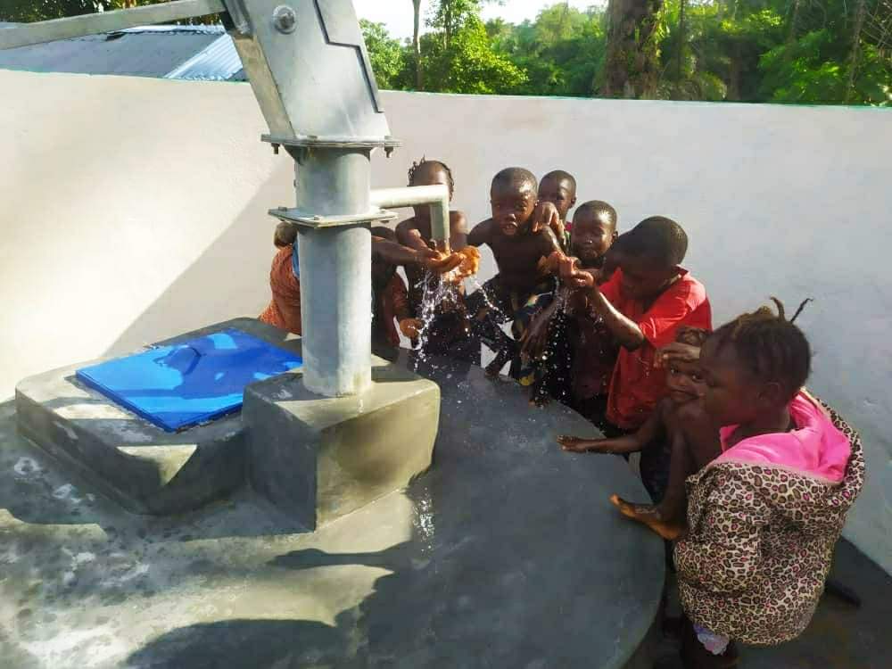 niños de Sierra Leona bebiendo de un pozo recien construido